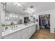 Bright main bathroom featuring double sinks, a large mirror, and a walk-in closet at 18132 W Cardinal Dr, Goodyear, AZ 85338