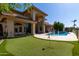 Expansive backyard with putting green, pool, water feature, and covered patio at 1834 E Willow Tree Ct, Gilbert, AZ 85234