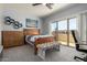 Bedroom with plank flooring, ceiling fan, work space, and sliding glass doors to the balcony at 1834 E Willow Tree Ct, Gilbert, AZ 85234