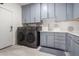 Well-equipped laundry room with gray shaker cabinets, modern machines, and bright countertops at 1834 E Willow Tree Ct, Gilbert, AZ 85234