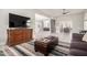 Open concept living room boasts a stylish rug and ornate wooden cabinet under the television at 1834 E Willow Tree Ct, Gilbert, AZ 85234