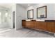 Modern bathroom with double vanity, spacious mirrors, walk-in shower and plank flooring at 1834 E Willow Tree Ct, Gilbert, AZ 85234