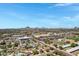 Expansive aerial shot of a residential area featuring tidy homes, streets, and mountains in the distance under a bright sky at 1940 E Indianola E Ave, Phoenix, AZ 85016