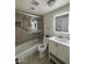 Well-lit bathroom featuring an updated vanity with an illuminated mirror, a bathtub with a shower, and neutral tiling at 1940 E Indianola E Ave, Phoenix, AZ 85016