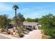 Charming home with desert landscaping, a palm tree, and a spacious driveway leading to a gated entrance at 1940 E Indianola E Ave, Phoenix, AZ 85016