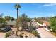 Charming home featuring desert landscaping, a tall palm tree, and a spacious driveway leading to a gated entrance at 1940 E Indianola E Ave, Phoenix, AZ 85016