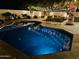Stunning backyard with a private pool, lush landscaping, and string lights for evening relaxation and enjoyment at 1953 W Lark Dr, Chandler, AZ 85286