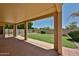 Covered patio overlooking landscaped backyard with grass, pool, and secure fencing at 21141 N 79Th Ave, Peoria, AZ 85382