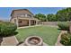 Spacious backyard with lush green lawn, fire pit, and a fenced pool area for outdoor enjoyment at 21141 N 79Th Ave, Peoria, AZ 85382