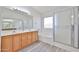 Well-lit primary bathroom with double sinks, a tub, and a separate glass shower at 21141 N 79Th Ave, Peoria, AZ 85382