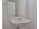 Bright bathroom featuring a pedestal sink, white cabinets, and a large mirror at 21141 N 79Th Ave, Peoria, AZ 85382