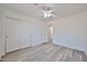 Bright bedroom with wood-look floors, white ceiling fan, closet, and neutral walls at 21141 N 79Th Ave, Peoria, AZ 85382