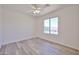 Light-filled bedroom with wood-look floors, white walls, ceiling fan, and window view at 21141 N 79Th Ave, Peoria, AZ 85382