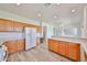 Well lit kitchen featuring white appliances, a work desk and ample wood cabinetry at 21141 N 79Th Ave, Peoria, AZ 85382