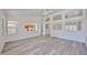Bright, open-concept living room with arched windows, wood floors, and modern ceiling fan at 21141 N 79Th Ave, Peoria, AZ 85382