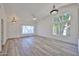 Bright, open-concept living room featuring modern light fixtures and beautiful wood floors at 21141 N 79Th Ave, Peoria, AZ 85382