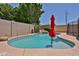 Private backyard pool with rock waterfall feature and red umbrella provides a serene outdoor retreat at 21141 N 79Th Ave, Peoria, AZ 85382