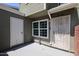 Home exterior featuring an entrance with a security door and small patio area at 2301 E University Dr # 210, Mesa, AZ 85213