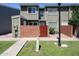 Two story townhome with well-manicured grass, a brick wall, and a wooden gate at 2301 E University Dr # 210, Mesa, AZ 85213