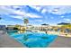 Community Pool featuring palm trees, lounge chairs, clear skies, and mountain views at 23075 W Arrow Dr, Buckeye, AZ 85326