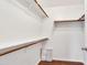 Spacious walk-in closet with wood shelving and laminate flooring at 23075 W Arrow Dr, Buckeye, AZ 85326