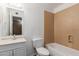 Full bathroom featuring tub, toilet and vanity with decorative framed mirror at 233 E 7Th Dr, Mesa, AZ 85210