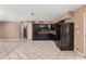 Kitchen featuring dark cabinetry, tile floors, and open access to the dining area at 233 E 7Th Dr, Mesa, AZ 85210