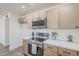 Modern kitchen featuring stainless steel appliances, white countertop, and custom wood cabinets at 2337 E Contessa St, Mesa, AZ 85213