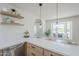 Kitchen featuring stainless steel appliances, quartz countertops, floating shelves, and a cozy bay window at 2337 E Contessa St, Mesa, AZ 85213