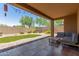 Inviting covered patio with seating, lush artificial grass, and landscaped surroundings at 2458 W Warren Dr, Anthem, AZ 85086