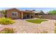 Landscaped backyard with a cozy covered patio and artificial grass, designed for outdoor living and relaxation at 2458 W Warren Dr, Anthem, AZ 85086