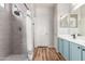Modern bathroom featuring a stylish shower, vanity with blue cabinets, and sleek fixtures at 2458 W Warren Dr, Anthem, AZ 85086