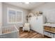 Bright Bedroom featuring stylish decor, a white crib, and a comfortable seating area at 2458 W Warren Dr, Anthem, AZ 85086