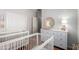Shared Bedroom featuring two white cribs, dresser, and coordinated decor at 2458 W Warren Dr, Anthem, AZ 85086