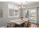 Bright dining area with wooden table set, lovely chandelier, and access to the backyard through sliding doors at 2458 W Warren Dr, Anthem, AZ 85086