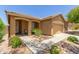 Charming single-story home featuring a well-manicured front yard, desert landscaping and a two-car garage at 2458 W Warren Dr, Anthem, AZ 85086