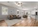Open-concept living room featuring wood floors, a comfortable gray couch, and plenty of natural light at 2458 W Warren Dr, Anthem, AZ 85086