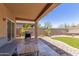 Covered patio with tiled floor, outdoor grill, and a view of the landscaped backyard at 2458 W Warren Dr, Anthem, AZ 85086