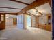 Open-concept living room with exposed beams, ceiling fan, and built-in display cabinet at 2701 E Allred Ave # 171, Mesa, AZ 85204