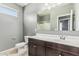 Bathroom with a large mirror, toilet and vanity with a white countertop at 3112 N 303Rd Dr, Buckeye, AZ 85396