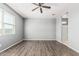 Spacious bedroom with hardwood floors, ceiling fan, and a large window at 3112 N 303Rd Dr, Buckeye, AZ 85396
