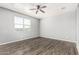 Bright bedroom with hardwood floors, ceiling fan, and a large window at 3112 N 303Rd Dr, Buckeye, AZ 85396