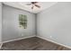 Comfortable bedroom featuring light grey walls, a window, and ceiling fan at 3112 N 303Rd Dr, Buckeye, AZ 85396