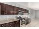 Modern kitchen with stainless steel appliances, granite countertops, and dark wood cabinetry at 3112 N 303Rd Dr, Buckeye, AZ 85396