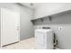 Functional laundry room with a large dryer, shelving, and tile flooring at 3112 N 303Rd Dr, Buckeye, AZ 85396