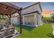Spacious backyard features a covered patio, artificial grass, and a pergola swing at 31332 N 137Th Ln, Peoria, AZ 85383