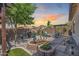 Landscaped backyard with a stone fire pit, outdoor seating, desert plants, and a view of the sunset at 31332 N 137Th Ln, Peoria, AZ 85383