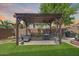 Inviting backyard pergola with comfortable seating, dining, and lush green artificial grass at 31332 N 137Th Ln, Peoria, AZ 85383