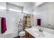Bright bathroom featuring a shower-tub combo, floral shower curtain, vanity, and wooden storage shelves at 31332 N 137Th Ln, Peoria, AZ 85383
