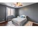 Bedroom with stylish gray walls, a ceiling fan, and a bright window covered by neutral-toned, sheer curtains at 31332 N 137Th Ln, Peoria, AZ 85383